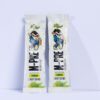 Two white pre-workout packets with a cartoon monkey logo, lemonade flavor, standing upright on a pastel purple surface.