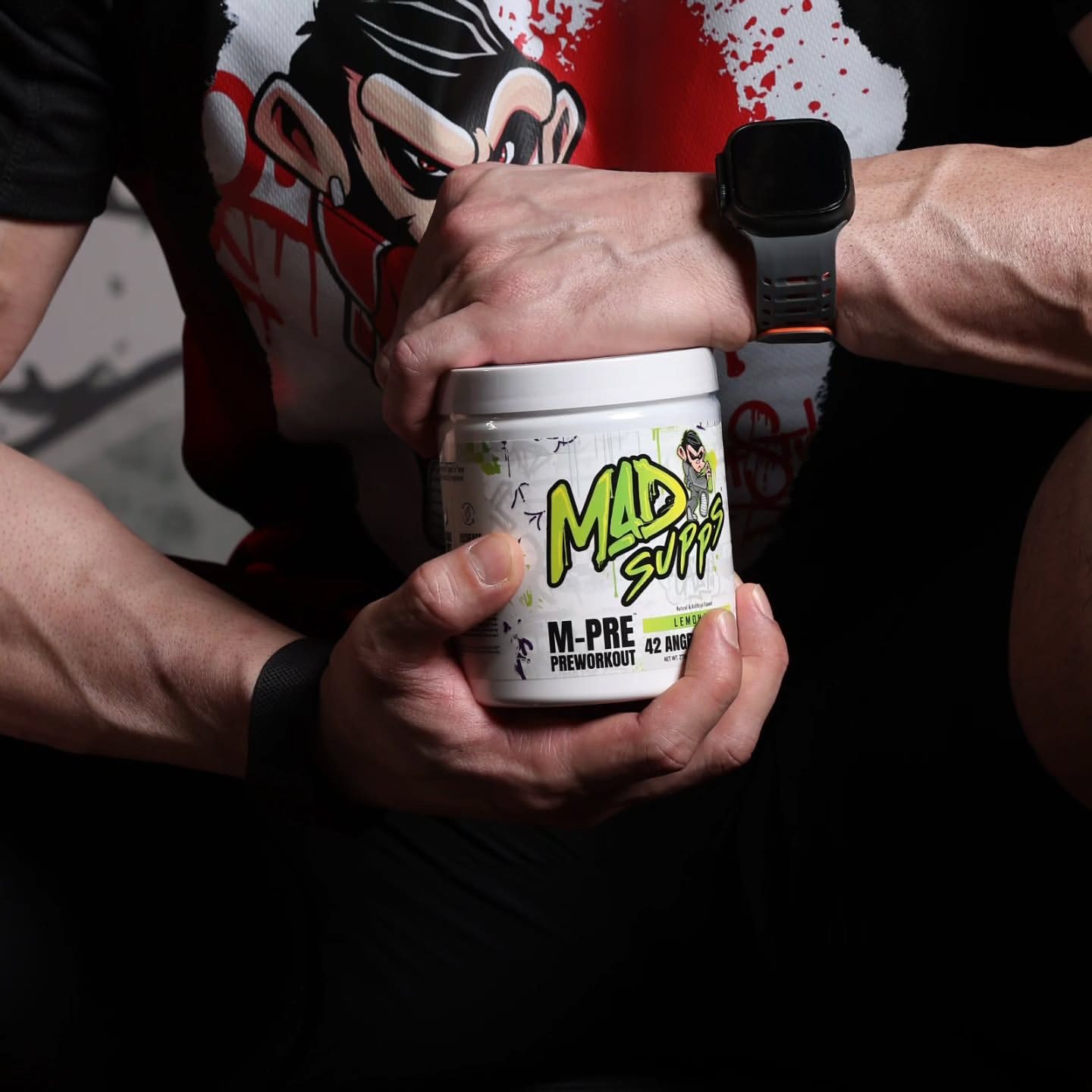 FITNESS MODEL HOLDING A BOTTLE OF M-PRE LEMONADE IN THE GYM